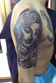 Promatrajući pola kipa tetovaže Bude