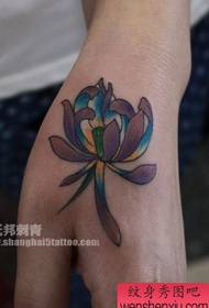 Tytön käsivarsi, pieni värillinen lootuksen tatuointikuvio