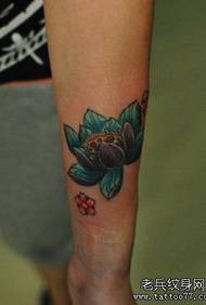 O brazo da rapaza ten bo patrón de tatuaxe de loto colorido