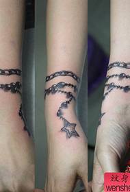 Krásné pěticípé tetování hvězdným náramkem na dívčím zápěstí