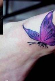 Прекрасан узорак мале тетоваже лептира на запешћу лепе жене