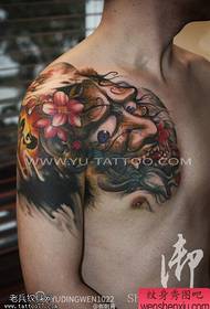 Напівзапечене традиційне кольорове твір-татуювання ділиться тату-шоу.