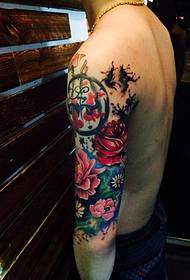 pokaz tatuażu męskiego ramienia z kwiatem