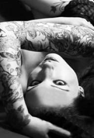 Girl's arm op zwart grijs punt doorn kleine verse plant wijnstok bloem arm tattoo foto