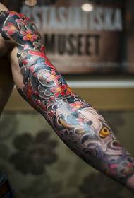 Uzņemiet uzkrītošā krāsu ziedu rokas pūķa tetovējuma attēlu