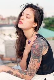 Убава девојка со тетоважа со цветни рака