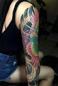 La belleza de pelo largo tiene una elegante imagen de tatuaje de Phoenix de brazo de flor
