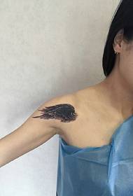 in ôfbylding fan in famke fan feather tattoo ûnder it sleutelbeen