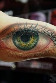 pola tato mata hijau di bagian dalam lengan besar