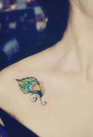 beautiful peacock feather tattoo at the clavicle