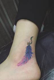 Colorful feather tattoo on bare feet