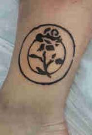Augu tetovētās zēnu potītes uz apaļajiem un rožu tetovējuma attēliem