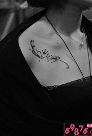 „Clavicle“ kūrybos vainiko juodos ir baltos spalvos tatuiruotė