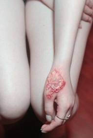 тиграста уста прекривена ожиљцима ружичастим узорком тетоваже малог цвета
