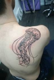 Knaboj de tatuaj meduzoj ĉe la dorso de la nigra meduzo tatuaje