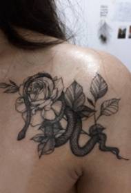 सरल रेखाओं के काले बिंदुओं की पीठ पर लड़कियां फूल और साँप टैटू चित्र लगाती हैं