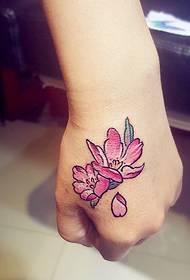 delikat och vacker tatuering med blommatatueringar på handens baksida