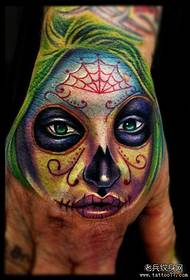 a colorful death girl tattoo on the back of the hand