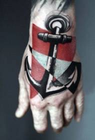 mano maschile tatuata a mano sul retro di una foto colorata del tatuaggio dell'ancora