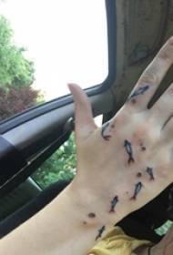ruku natrag tetovaža dječakova ruka na crnoj slici male tetovaže ribe