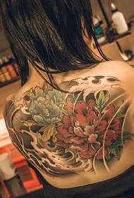 Beautiful flower tattoo on the back of the brunette beauty