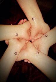 small heart-shaped tattoo on the wrist between girlfriends