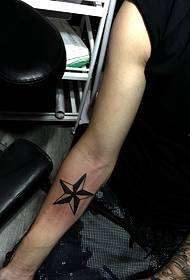 simple five-pointed star tattoo on the wrist of a man