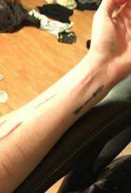 Ragazza europea è americana di tatuaggi di polso in polza di tatuaggio di freccia nera