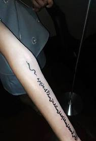 Engelska ordet tatuering på flickans handled