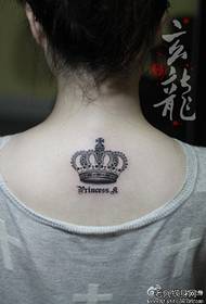 Девушка с черно-белой татуировкой короны с изысканной модой на спине