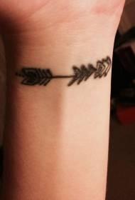 Маленькая черная стрела татуировки на запястье девушки