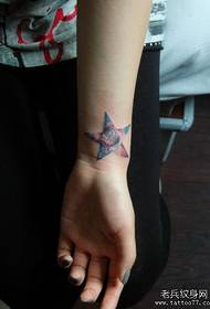 girl's wrist with five-pointed star and starry tattoo pattern