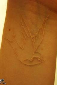 Femeie Imagine de tatuaj înghițitor alb la încheietura mâinii