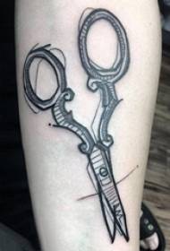 Jongens arm op zwart grijs punt doorn geometrische eenvoudige lijn hulpmiddel schaar tattoo foto