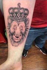O braço do menino na foto de tatuagem de leão de esboço preto cinza coroa