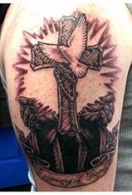 Boy's arm on black gray point cross and white dove tattoo picture