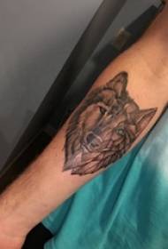 Jongens arm op zwarte prik geometrische eenvoudige lijn stiksels klein dier wolf hoofd tattoo foto