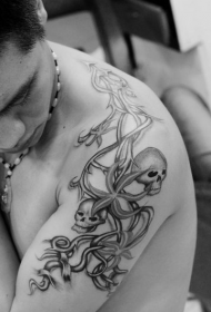 Brazo grande do home, branco e negro, patrón de tatuaxe en leito de flores