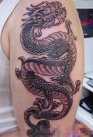 Jongens arm op zwarte schets creatieve persoonlijkheid dominante draak totem tattoo foto