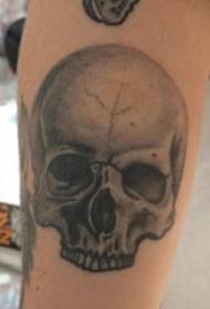 tatuaxe de cráneo, cinza negra, tatuaxe no brazo do neno