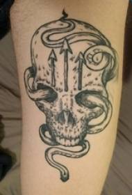 Čūskas tetovējuma zēna roka uz čūskas tetovējuma galvaskausa attēla