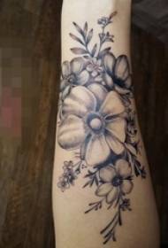 Girl's arm on black gray pricking technique plant material flower tattoo picture