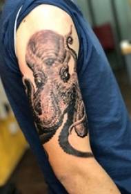 Dječakova ruka na crno sivoj crtežu skice bodljikave vještine dominirajuća slika tetovaže hobotnice
