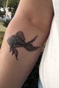 Braço de estudante do sexo masculino tatuagem peixinho preto na foto de tatuagem peixinho preto