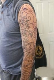 Еўрапейская і амерыканская татуіроўка на кветцы на руцэ мужчынскага вучня на малюнку татуіроўкі на чорнай кветцы