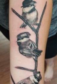 Tatuaje birda knabino kun nigra birda tatuaje bildo sur brako