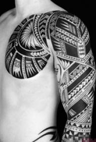 Boy with arm on black totem tattoo pattern
