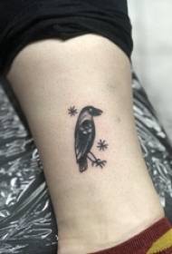 Baile vitellu tatuatu di l'animali maschile nantu à a piccula foto di tatuatu d'uccello neru