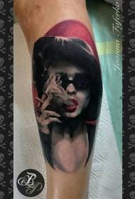 Цветна татуирана жена с пушене на изкушението на краката