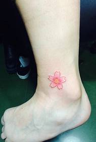 Pequena tatuagem de flor de cerejeira fresca na panturrilha é muito bonita